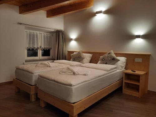 een slaapkamer met 2 bedden en een raam bij B&B alla Spiazzőla in Spormaggiore