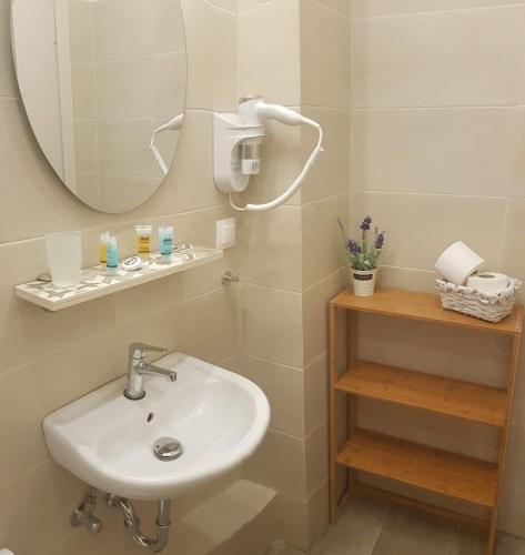 a bathroom with a sink and a mirror at Tsakalos Apartments in Edipsos