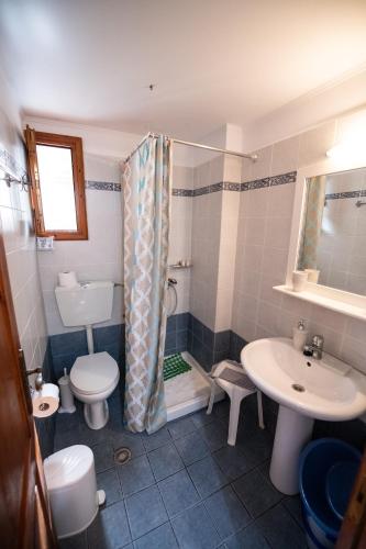 a bathroom with a shower and a toilet and a sink at Katikies Stamatias Studios & Maisonettes in Agnontas