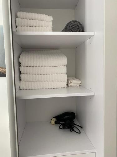 直布羅陀的住宿－CP Top floor luxury studio，架子上带白色毛巾的衣柜