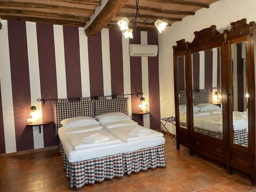 a bedroom with two beds and a mirror at Agriturismo Il Poggiarello in Siena