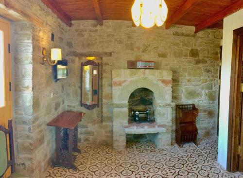 a room with a stone wall with a stone fireplace at SARI KEÇİ TAŞ OTEL in Gokceada Town