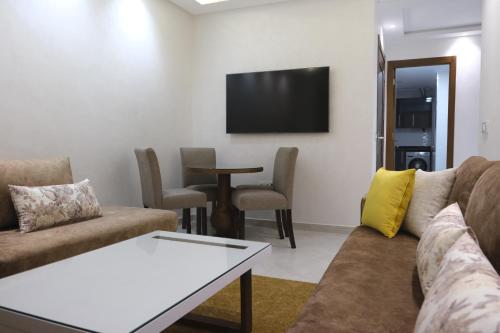 a living room with a couch and a table at Résidence jannat in Fnidek
