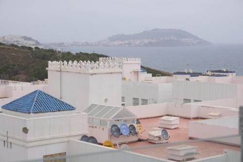 a view of the roofs of white buildings and the ocean at Résidence jannat in Fnidek