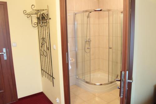 a shower in a bathroom with a glass door at Zajazd Skorpion B&B in Oświęcim