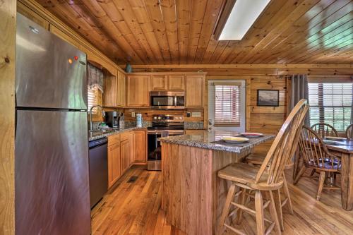 a kitchen with a stainless steel refrigerator and wooden cabinets at 1 Mi to Dollywood Quiet Cabin with Hot Tub! in Sevierville