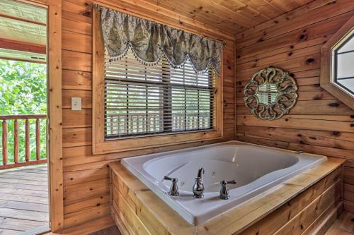 a large tub in a wooden bathroom with a window at 1 Mi to Dollywood Quiet Cabin with Hot Tub! in Sevierville
