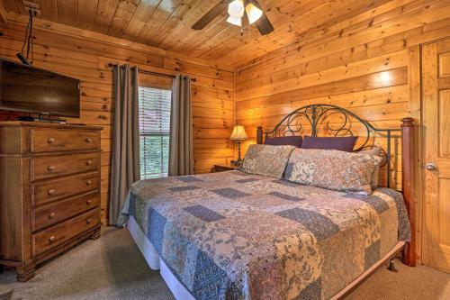 a bedroom with a bed and a dresser and a television at 1 Mi to Dollywood Quiet Cabin with Hot Tub! in Sevierville