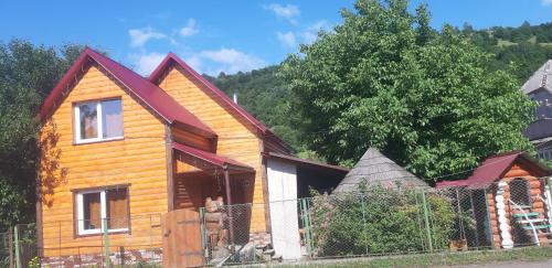 a wooden house with a fence in front of it at Готель Людмила in Synevyr