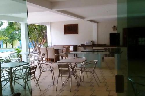 um restaurante com mesas e cadeiras e uma piscina em Hotel Praia Bela em Salinópolis