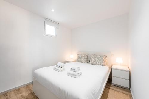 um quarto branco com uma cama branca e uma janela em GuestReady - Palacio Garden 13 no Porto