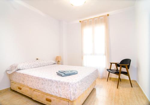 1 dormitorio blanco con 1 cama y 1 silla en Apartamento de 4 dormitorios a tan sólo 2,5 km de la Playa San Juan, en San Juan de Alicante