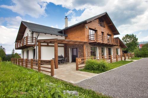 a wooden house with a porch and a deck at Chata Panoráma Zuberec in Zuberec