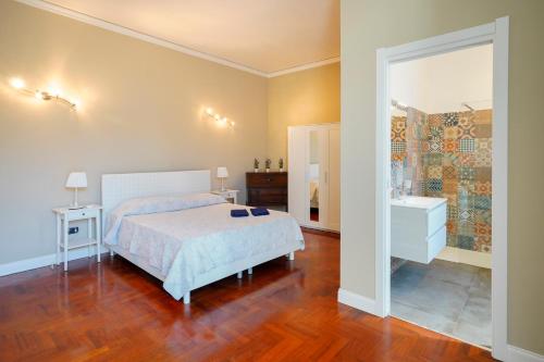 a bedroom with a bed and a bathroom with a mirror at Palazzo GiuFa in Syracuse