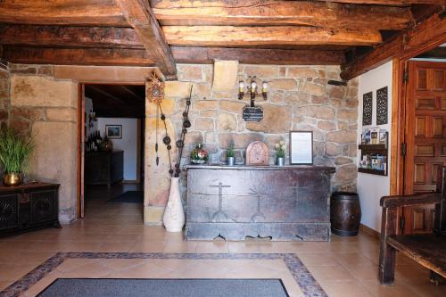 Habitación grande con pared de piedra y techo de madera. en La Casa De Los Pedros, en Villar