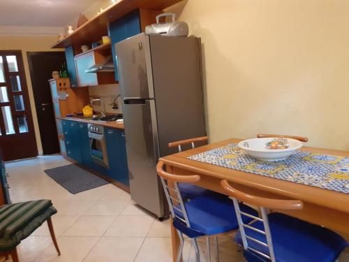 a kitchen with a table and a refrigerator at La casa di Ladì in Scilla
