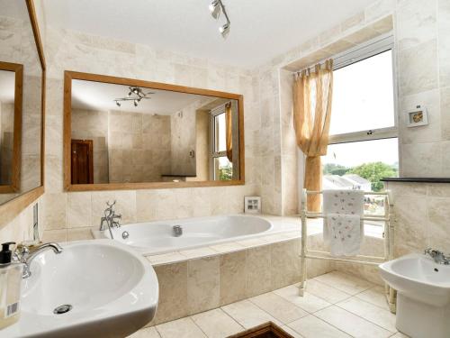 a bathroom with a tub and a sink at Wavecrest in Pwllheli