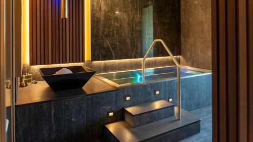 a bathroom with a bath tub with a sink at HOTEL Hraniční zámeček in Hlohovec