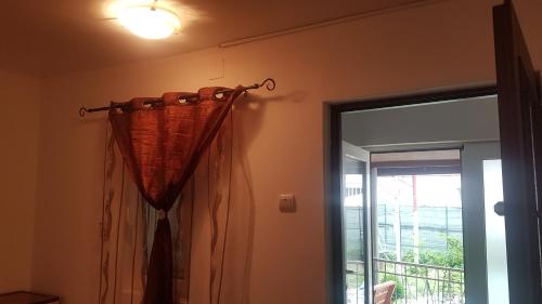 uma cortina pendurada num quarto com uma janela em CASA AMBROZIA em Eforie Sud