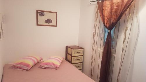 um quarto com uma cama com duas almofadas e uma cómoda em CASA AMBROZIA em Eforie Sud