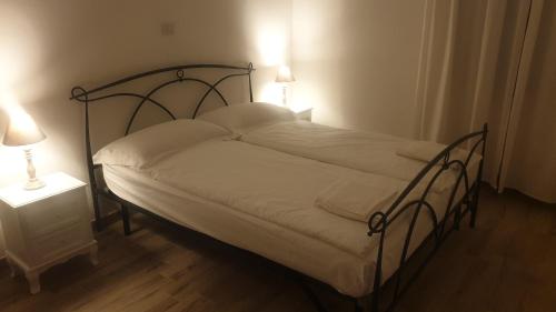a bed in a room with two lamps and a bed sidx sidx sidx at Appartamento Le Rose in Ossuccio