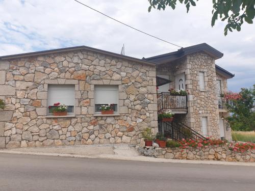 a stone house with two windows and a balcony at DELIA in Međugorje