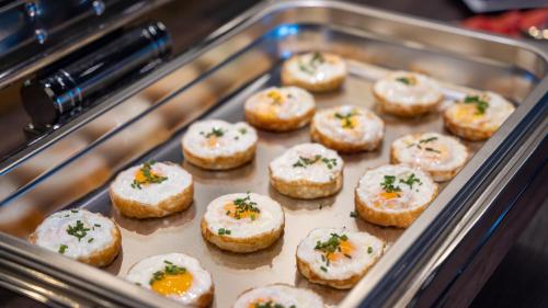 a tray of donuts with cheese and sprinkles on them at HOTEL Hraniční zámeček in Hlohovec