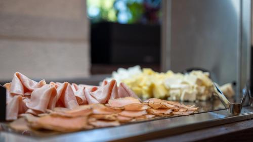 a tray of food with meat and other foods at HOTEL Hraniční zámeček in Hlohovec