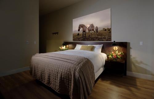 a bedroom with a bed and a painting of horses at Gateway Hotel, Trademark Collection by Wyndham in Copper Cove Subdivision