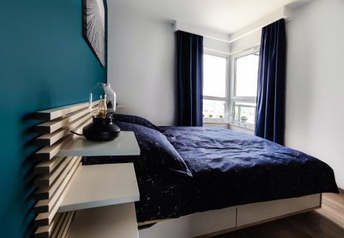 a bedroom with a bed with a night stand and a window at SUNRISE HOME APARTMENTS - LIGHTHOUSE in Gdańsk