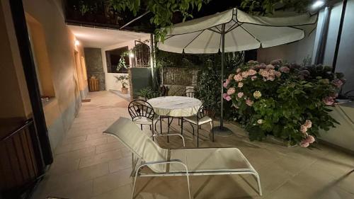 a table and chairs with an umbrella and flowers at Luxury APARTMAN BILI in Podgora