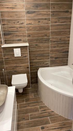 a bathroom with a tub and a toilet and a sink at Luxury APARTMAN BILI in Podgora