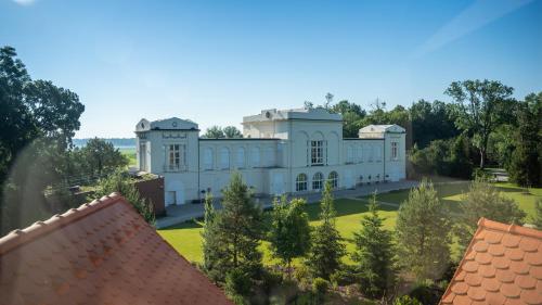 an aerial view of a white mansion with trees at HOTEL Hraniční zámeček in Hlohovec