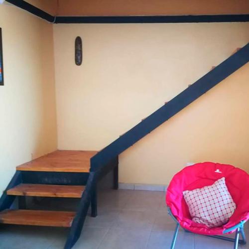 a room with a stair case and a red chair at Cabaña Oasis de Pica in Pica