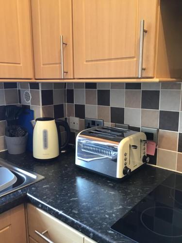 a toaster sitting on a counter in a kitchen at Largs Holiday Apartment in Largs