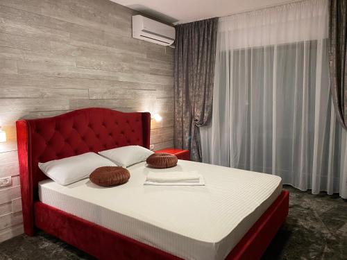 a bedroom with a red bed with two pillows on it at CLB Residence in Eforie Nord