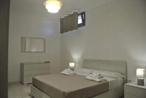 - une chambre avec 2 lits et des serviettes dans l'établissement Salento Holiday, à San Cassiano