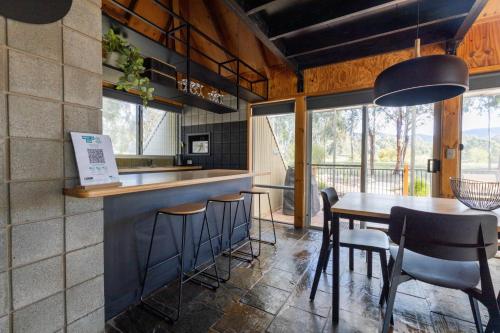 una cucina con bar, tavolo e sedie di Grampians Getaway a Halls Gap