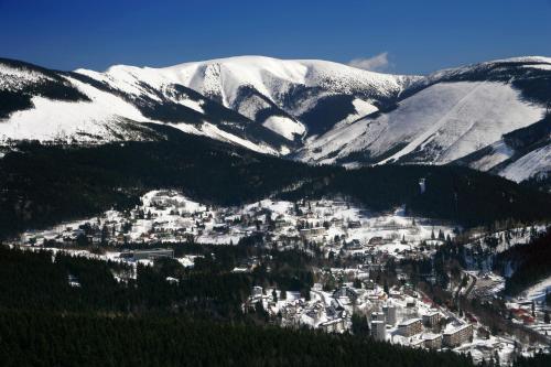 an aerial view of a town with snow covered mountains at PENSION ANNA in Špindlerův Mlýn