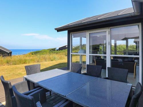 ロンストラップにある6 person holiday home in Hj rringの海を望むパティオ(青いテーブル、椅子付)