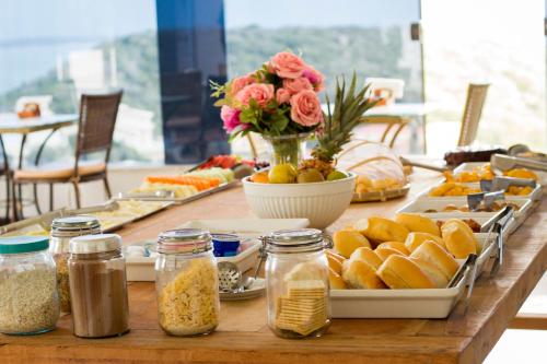 een tafel met borden met voedsel en bloemen bij Eny Boutique Hotel & Spa in Búzios