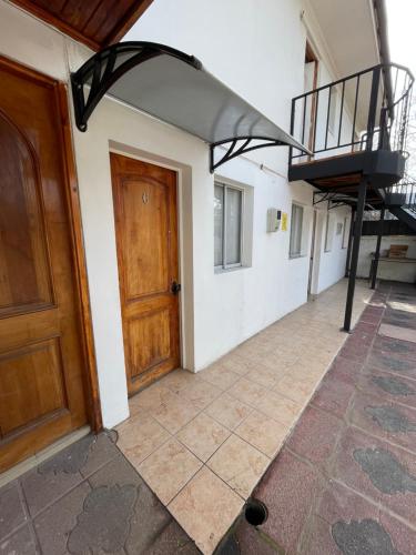 a hallway with a wooden door and a spiral staircase at Residencial Astorga in Rancagua