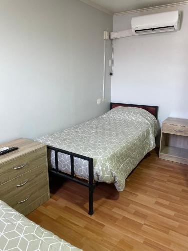 a small bedroom with a bed and a dresser at Residencial Astorga in Rancagua