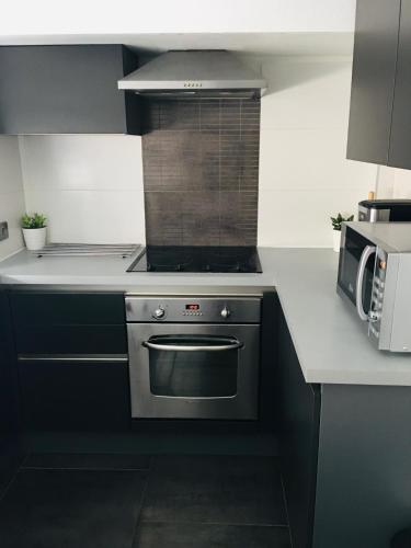 une cuisine avec une cuisinière et un micro-ondes dans l'établissement Magnifique Appartement au cœur de Nancy, à Nancy