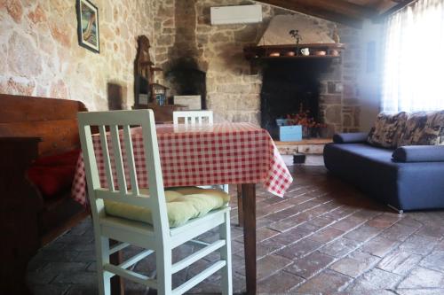 una mesa y sillas en una sala de estar con chimenea en Apartmani Jelena, en Poreč