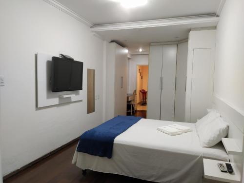 um quarto com uma cama e uma televisão na parede em Estadia das Gerais - Casa de hóspedes adorável com Jacuzzi em Ouro Preto