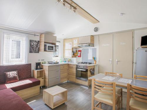 Una cocina con un sofá y una mesa en una habitación. en Mobile Home in Saint-Jean near Beach & Pool, en Saint-Jean-de-Monts