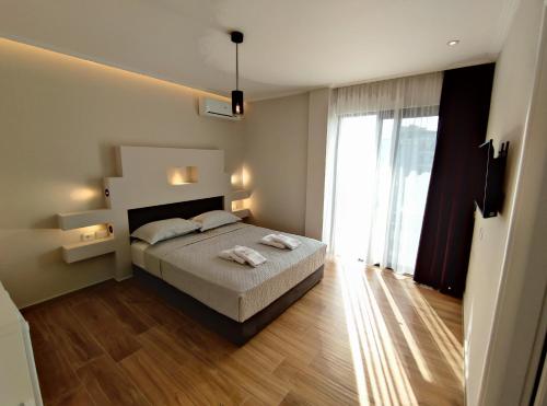 een slaapkamer met een bed en een groot raam bij Villa Primo Opus in Ksamil