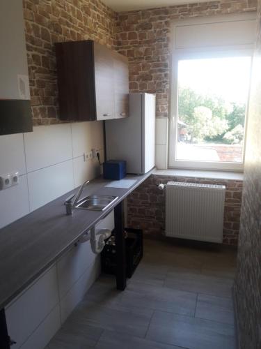 a kitchen with a sink and a window in it at Pension Zum Holzwurm Wittenberge in Wittenberge