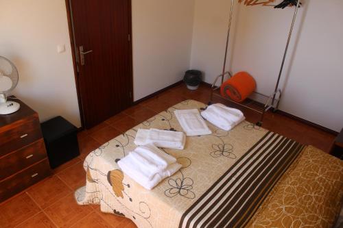 a bedroom with a bed with towels on it at Bella Italia Bem Estar Dona Adelina in Ponta Garça